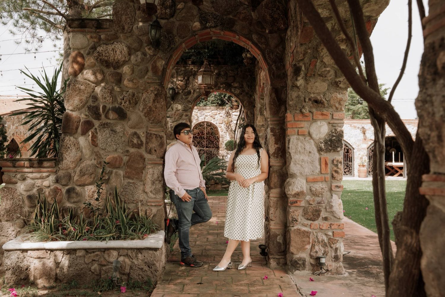 Isabella y Lyzander bajo un arco de piedra en Hacienda Los Rincones